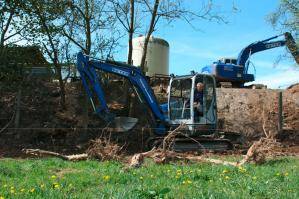 Bagger von BEYER-Mietservice auf Wiese im Einsatz