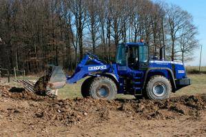 Radlader von der Seite beim Erdtransport auf Baustelle