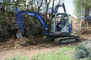 Bagger bei Erdarbeiten auf einer Wiese