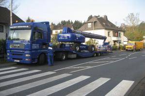 LKW-Tieflader auf Straße, beladen mit Diesel-Teleskopbühne