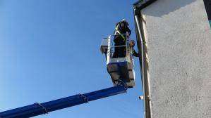 2 Personen im Arbeitskorb einer 27 m LKW-Arbeitsbühne bei Arbeiten an Fassade