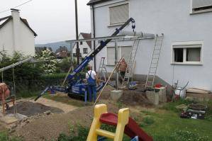 Minikran MC 55.1 bei Kranarbeiten in Garten im Einsatz