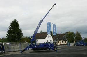 Abgestützter und ausgefahrener Minikran MC 168.4 K auf Firmengelände