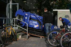 Miniraupenkran wird über eine Treppe in Gebäude verbracht