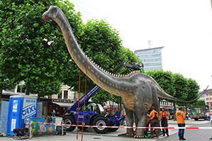 Starrer Telelader beim Aufbau eines lebendgroßen Dinosaurier in der Innenstadt in Bochum