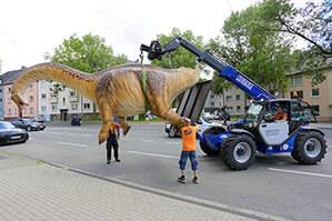 Telelader TSS 1030 beim Transport eines Dinosauriers über eine Straße in Bochum