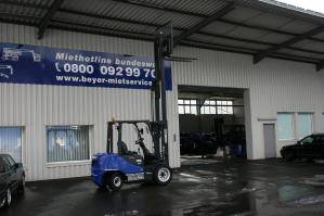 3,5 t Dieselstapler mit angehobenem Hubmast vor BEYER-Werkstatthalle