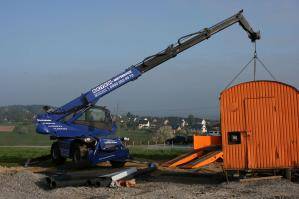 Abgestützter drehbarer Telelader beim Lastentransport