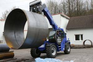 Schwerlast-Teleskopstapler mit 12 t Tragkraft hebt Stahlrohr von Windkraftanlage